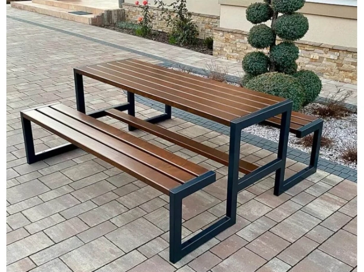Biergartenbank und Tisch in einer gemütlichen Gartenecke platziert.