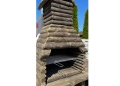 Ovale Grillstation aus Stein – massiver Holzkohlegrill für moderne Gärten.