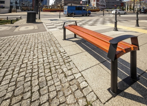Parkbank Centurion ohne Rückenlehne mit Urbanen Hintergrund.